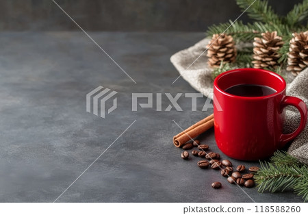 Warm coffee in a red mug surrounded by winter spices and pine branches on a dark tabletop 118588260