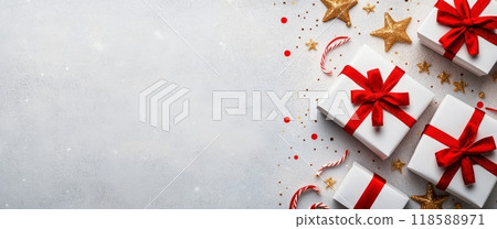 White gift boxes with red ribbons and candy canes on a light surface White gift boxes with red ribbons and candy canes on a light surface 118588971
