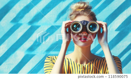 A woman is peering through binoculars while standing before a blue wall 118590075