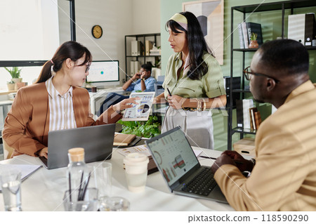 Collaborating in Modern Office with Team Members 118590290