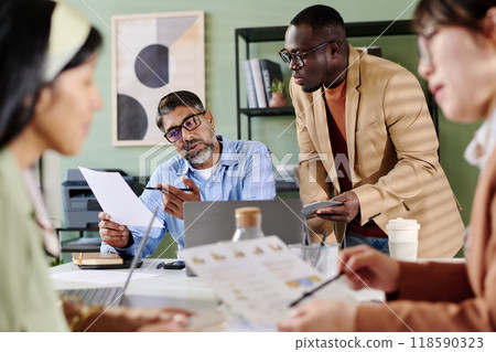 Discussing Business Strategy in Modern Office Setting Discussing Business Strategy in Modern Office Setting 118590323