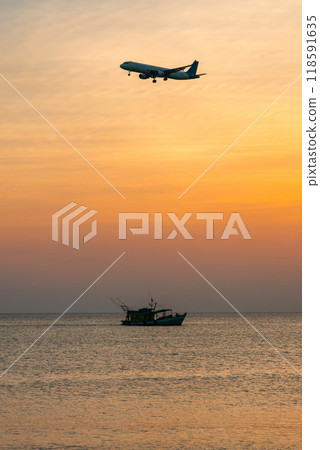 Passenger plane is landing over the sea and a floating fishing ship 118591635