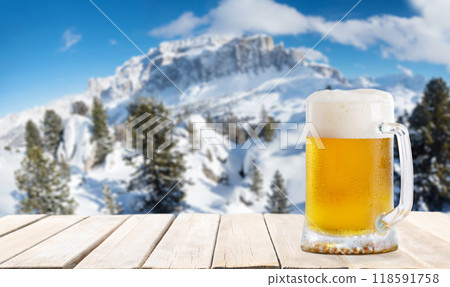 mug of beer on wooden table against winter landscape mug of beer on wooden table against winter landscape 118591758