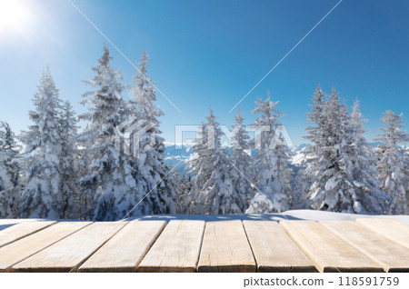 Empty wooden table against snowy firs and winter mountains background. Alps, Italy Empty wooden table against snowy firs and winter mountains background. Alps, Italy 118591759