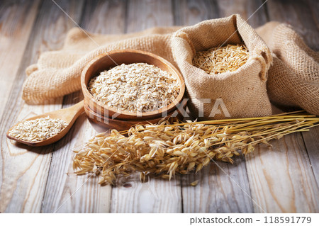 grains of oats, oatmeal and oats spikelets on wooden background grains of oats, oatmeal and oats spikelets on wooden background 118591779