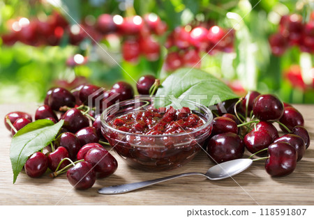 cherry jam and fresh fruits on wooden table in orchard garden cherry jam and fresh fruits on wooden table in orchard garden 118591807