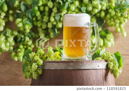 mug of beer and green hops on wooden beer barrel 118591825