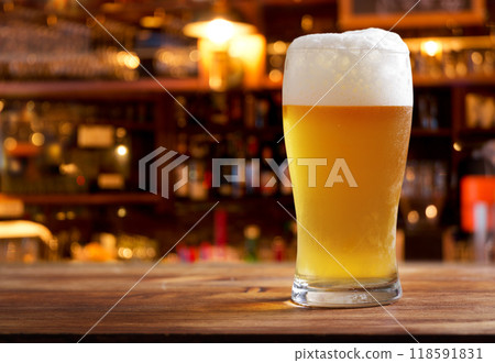 glass of beer in a bar on wooden counter 118591831