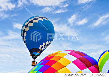 Colorful hot air balloon flying over blue sky with white clouds Colorful hot air balloon flying over blue sky with white clouds 118592200