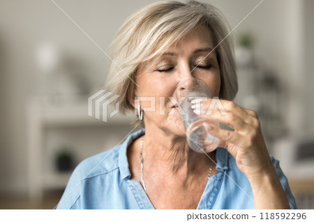 Closeup face older woman holding glass drinking still natural water 118592296