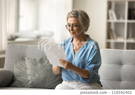 Woman read formal correspondence, review financial statement or paper letter 118592402