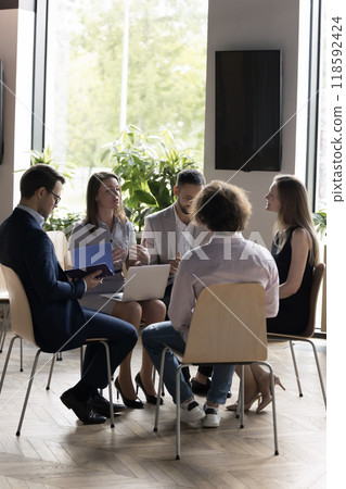 Business team sitting on chairs in circle, talking, brainstorming Business team sitting on chairs in circle, talking, brainstorming 118592424