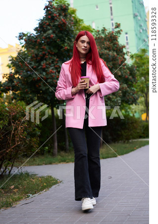 Young woman with red hair strolls through a city park in springtime Young woman with red hair strolls through a city park in springtime 118593328