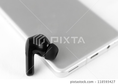 Smartphone and wireless earphones. Image of listening to music Smartphone and wireless earphones. Image of listening to music 118593427