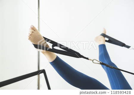 Image of a young woman's legs doing machine pilates Image of a young woman's legs doing machine pilates 118593428