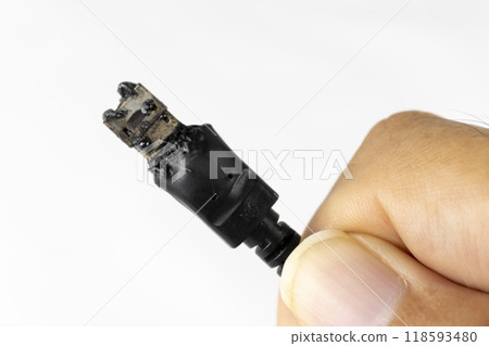 Man's hand holding a burnt USB connector Man's hand holding a burnt USB connector 118593480