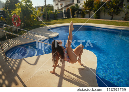 Graceful Youth Enjoying a Relaxing Time at a Beautiful Poolside during a Sunny Day Graceful Youth Enjoying a Relaxing Time at a Beautiful Poolside during a Sunny Day 118593769