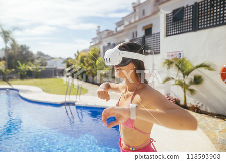 A Girl Delighting in Virtual Reality While Relaxing by the Pool on a Bright Sunny Day 118593908