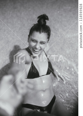 A Joyful Young Woman Having Fun While Playing in the Refreshing Water at the Beach 118593928
