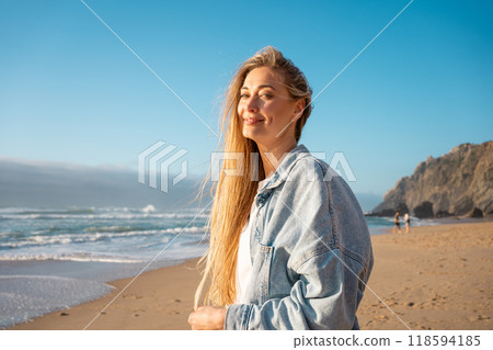 Happy woman in denim shirt on seashore against 118594185