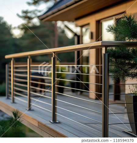 Stylish balustrade with discreet metal posts and wooden rail overlooking a scenic outdoor area Stylish balustrade with discreet metal posts and wooden rail overlooking a scenic outdoor area 118594370