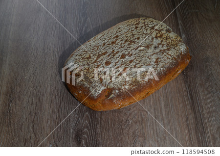 Loaf of rye bread with wooden board on old board, low angle view on table with copy space Loaf of rye bread with wooden board on old board, low angle view on table with copy space 118594508