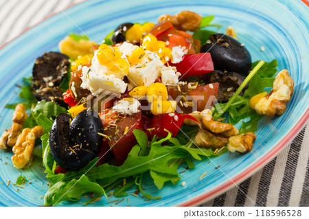 Salad of arugula with tomatoes, bell pepper, feta, walnuts 118596528