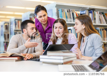 Group portrait of smiling positive engaged in research, working together in library 118596766