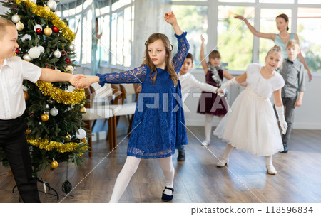 Little children practicing waltz dance in school-hall decorated with Christmas-tree Little children practicing waltz dance in school-hall decorated with Christmas-tree 118596834