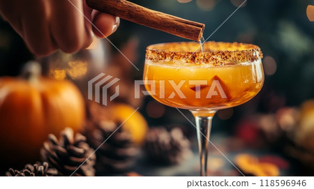 Close-up of a hand adding cinnamon to a fall-themed cocktail 118596946