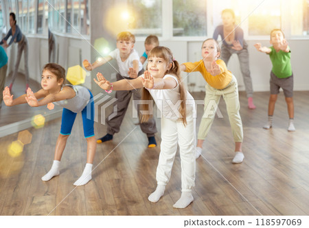 Group of preteen girls and boys enjoying active dance movement in studio Group of preteen girls and boys enjoying active dance movement in studio 118597069