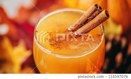 Close-up of a Glass of Pumpkin Spice Drink with Cinnamon Sticks 118597076