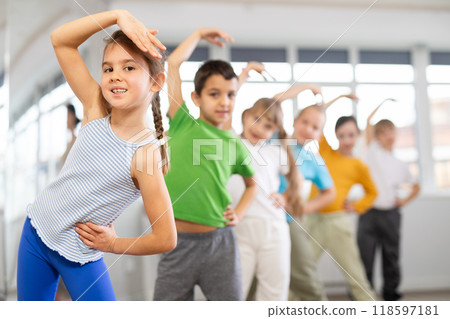 Children do warm-up exercises in studio, prepare for pair dance class 118597181