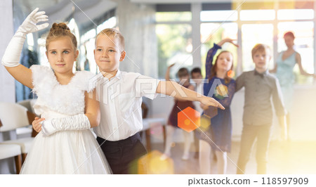 Little children in elegant dresses practicing waltz dance in school hall 118597909