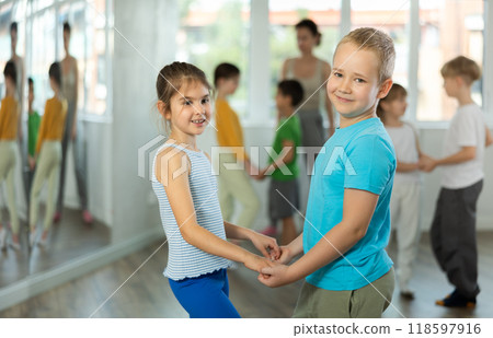 Girl paired up with boy and training to perform slow couple dance, rehearse performance. Girl paired up with boy and training to perform slow couple dance, rehearse performance. 118597916