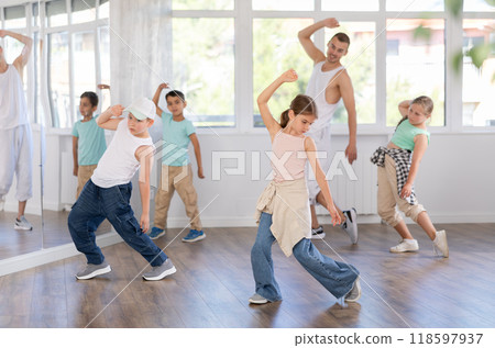 Preteen girl performing hip hop in group class for kids 118597937