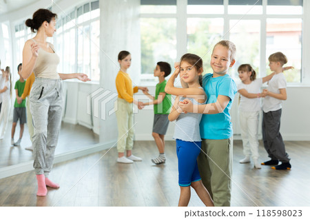Happy preteen children practicing ballroom dances in pairs in training hall 118598023
