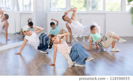 Preteen girl practicing hip hop choreography with peers and instructor Preteen girl practicing hip hop choreography with peers and instructor 118598055