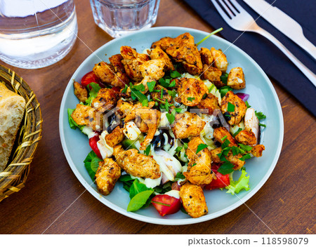 Popular dish of American cuisine is a warm Caesar salad with fried chicken and champignons Popular dish of American cuisine is a warm Caesar salad with fried chicken and champignons 118598079