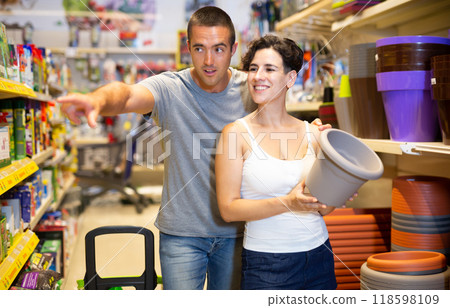Happy married couple choosing and buying flower pots in the horticultural section of supermarket 118598109