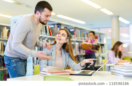 Woman and man studying together at library Woman and man studying together at library 118598186