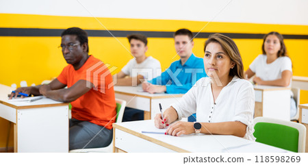 Portrait of focused female studying in classroom with colleagues Portrait of focused female studying in classroom with colleagues 118598269