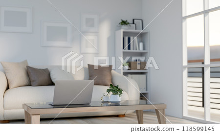 A rear view of a laptop on a coffee table in a contemporary apartment living room with a balcony. 118599145