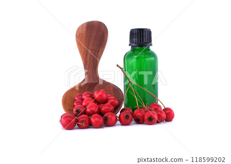 Hawthorn berries and essential oil bottle with wooden spoon isolated on white background 118599202