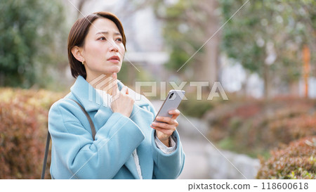 Woman using a smartphone (winter clothes, jacket, coat) 118600618