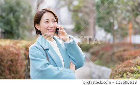 Woman talking on smartphone (winter clothes, jacket, coat) 118600619