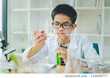 Asian male science students looking through a microscope and tests of plants in the classroom. Learning about scientific experiments on plant species. Asian male science students looking through a microscope and tests of plants in the classroom. Learning about scientific experiments on plant species. 118600777