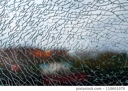 A shattered glass texture beautifully blurs the vibrant colors of the garden beyond, capturing a moment of fractured reflection 118601078