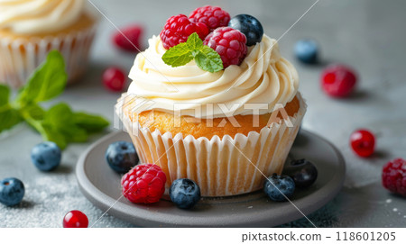 Vanilla bean cupcake with vanilla buttercream frosting, topped with fresh berries and mint leaves 118601205