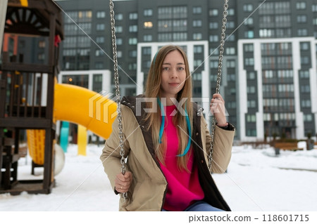 Woman Sitting on Swing in Snow 118601715